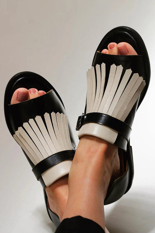 mules à bout rond ouvert et franges contrastées.