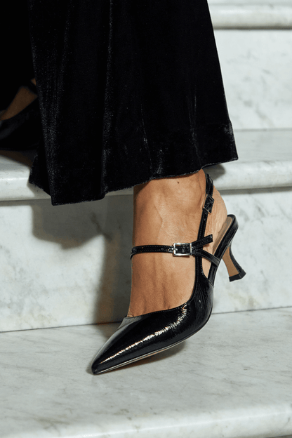 talons slingback noirs brillants à bout effilé.