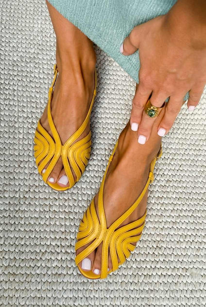 sandales plates d'été noires en cuir à brides style cage et bout ouvert.